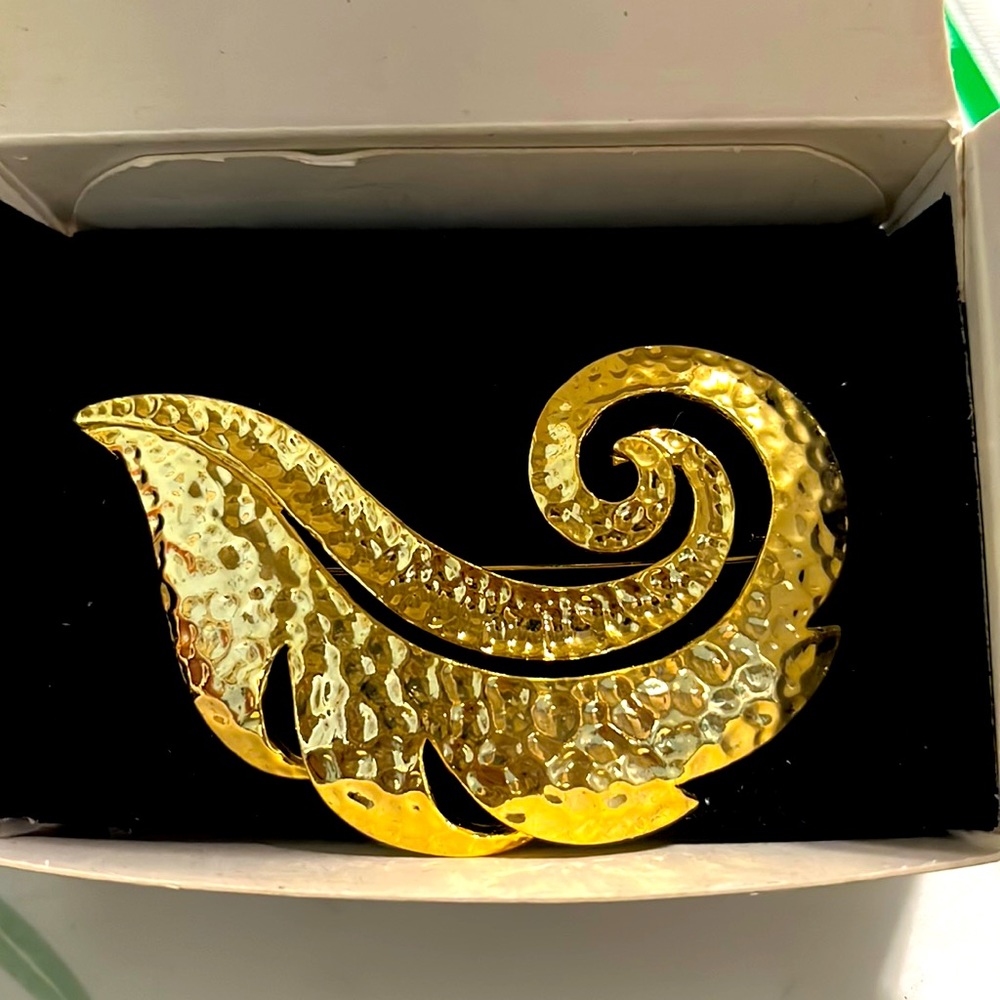 Goldtone feather pin.